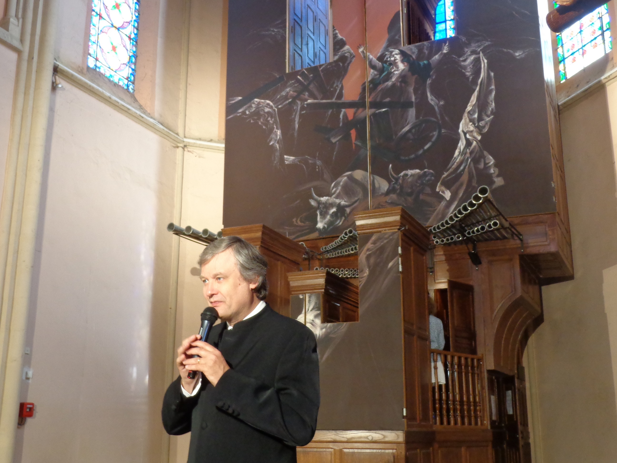 Michel Bourcier présente les oeuvres devant l'orgue fermé.JPG