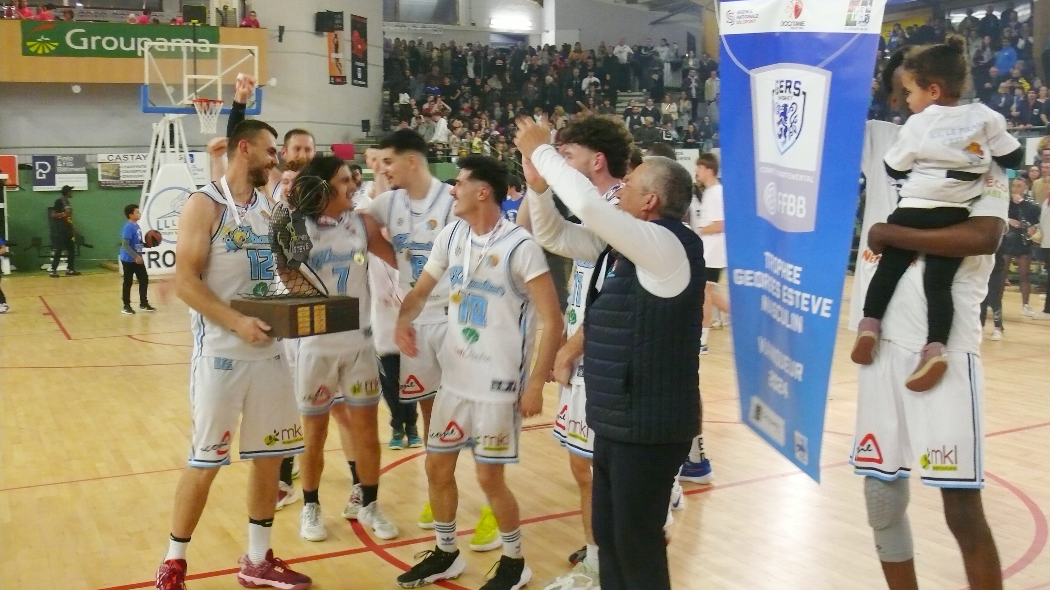 Le coach, Jean-Louis Degers, heureux de partager le trophée avec ses joueurs.