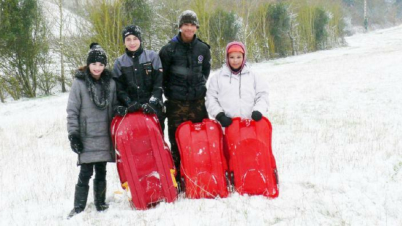 Heureux de glisser avec leur luge tout près de leur village