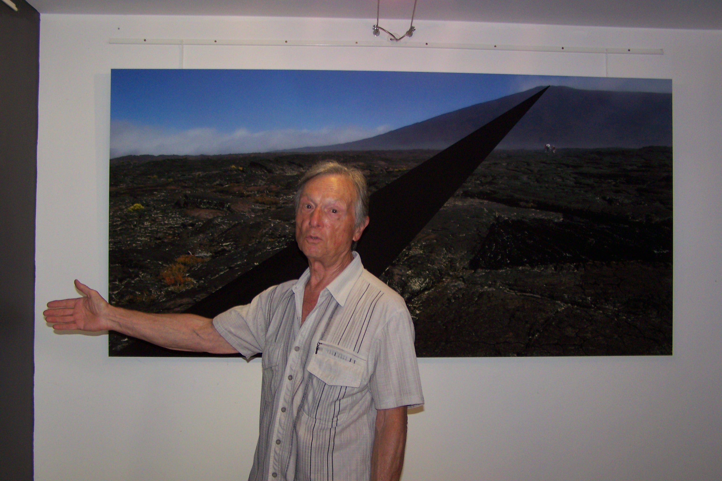 Louis Viel devant l'immense photo du Piton de la Fournaise à l'île de la Réunion