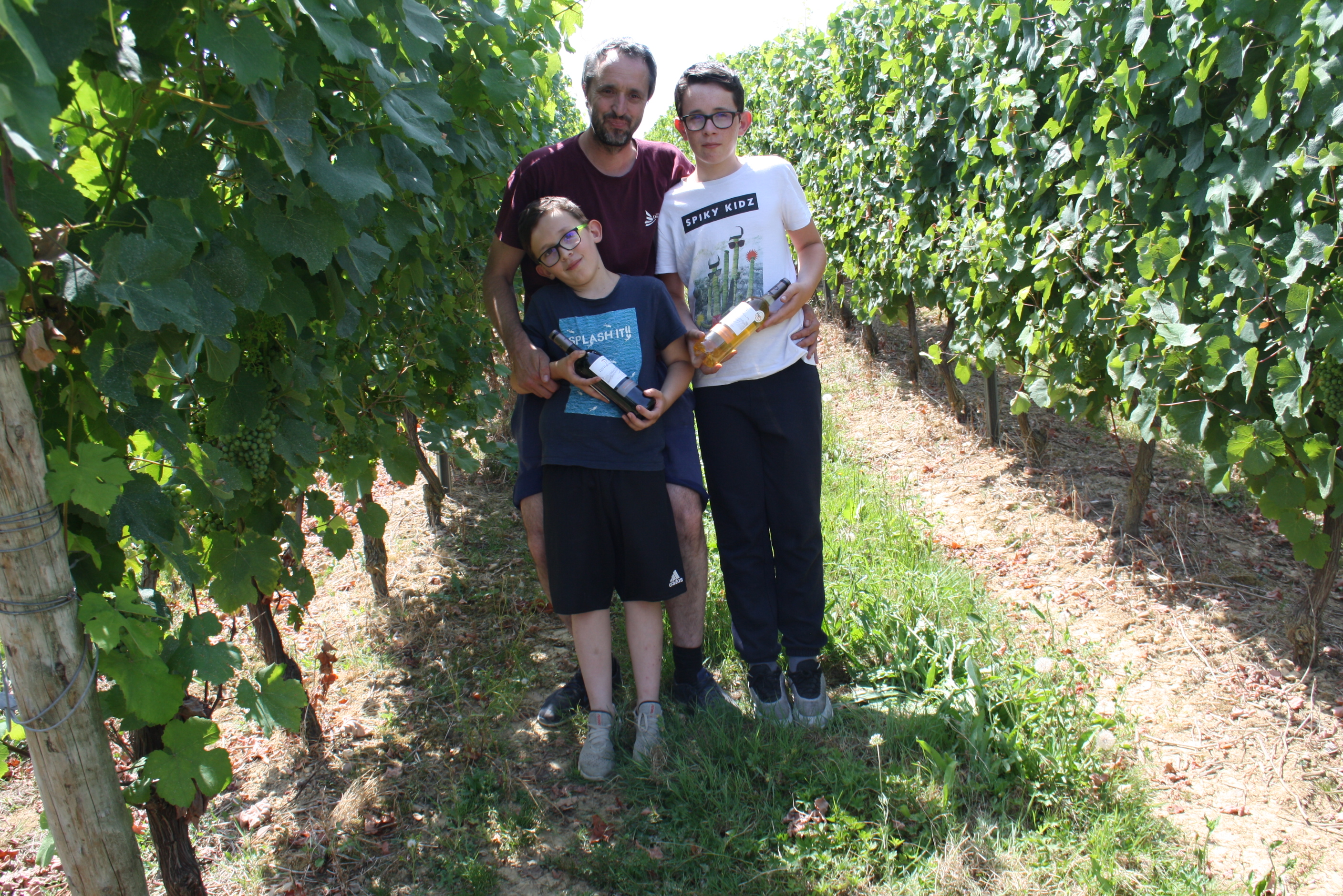 Nicolas Tortigue au milieu des vignes du domaine les Pyrénéeales à Madirana, entouré de des 2 fils.  © Crédit photo Lionel LEMAIRE