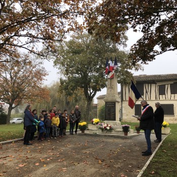 Devant le monument aux morts, le maire de Pauilhac M. Suarez, M. Claude Menegazzo et les enfants de l'école avec les époux Delmas.