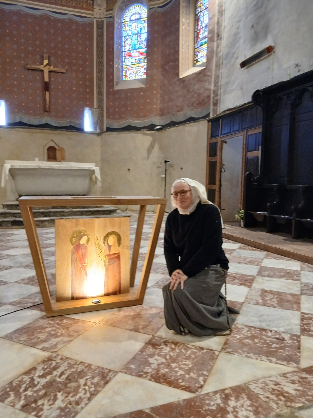 Sœur Alix Pauline,de l'ordre des Sœurs de Marie Etoile du Matin ,  agenouillée à côté de l'autel